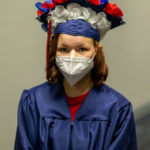 Graduate standing with cap and mask